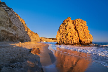 Fototapeta na wymiar Sun-lit rock on Fyriplaka beach, Milos, Greece. No people, sunset