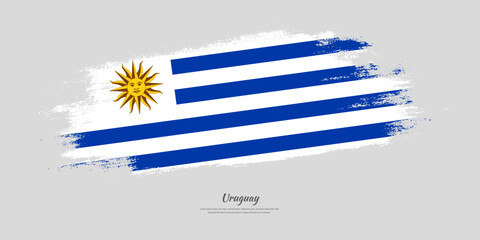 Happy Independence Day of Uruguay. National flag on artistic stain brush stroke background.