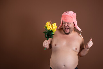 Happy fat florist with a bouquet in his hands. A man on a brown background. - obrazy, fototapety, plakaty