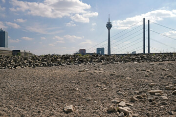 Fototapeta na wymiar Climate change - the Rhine dwindles and exposes rocks in the dry riverbed in Düsseldorf, Germany