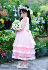 Obraz na płótnie Canvas cute asian flower girl holding flowers