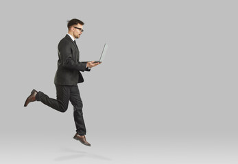 Male professional executive manager or financier who jumps with laptop symbolizing career growth....
