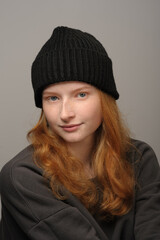 young girl model in black cap and grey jackett isolated on grey background. Product photo mockup for fashion brands and marketplaces.