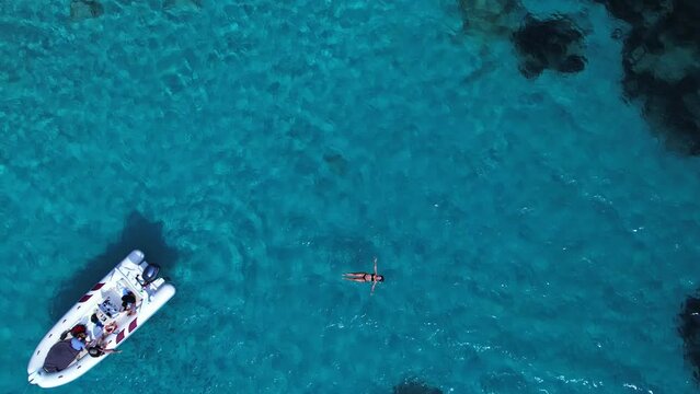 Bikini clad woman enjoying her stress free vacation at Isola di Spargi Itlay