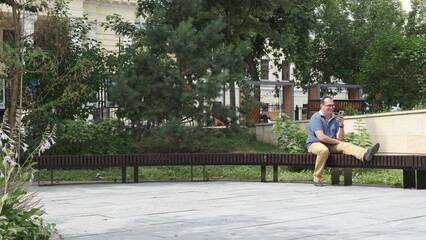 Young Man Reading With Digital Tablet At Park