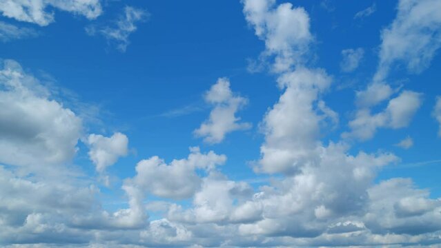 Cirrus or feather and cumulus on different layers clouds against a blue sky. Natural beautiful scene. Purity and serenity concepts. Timelapse.