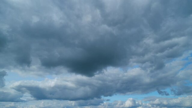 Floating fluffy clouds. Beautiful sunny blue sky with wispy smoky white cumulus and cirrus on different layers. Timelapse.