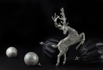 Christmass balls and silver glitter deer on black background