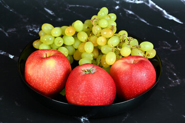 Red apples and green grapes in a bowl 
