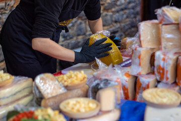 Mujer tapando el queso en un puesto del mercado navideño en Madrid.