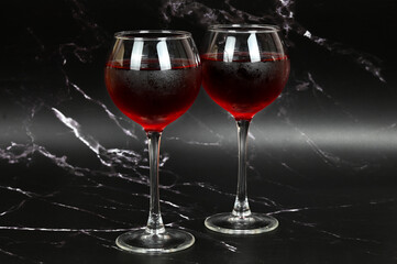 Two glasses with red wine on a dark background 