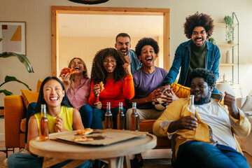 Friends cheering for soccer team at home.