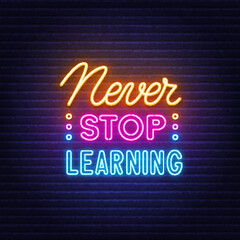 Never Stop Learning neon quote on a brick wall.