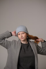 young girl model in light blue cap and gray coat isolated on grey background. Product photo mockup for fashion brands and marketplaces.