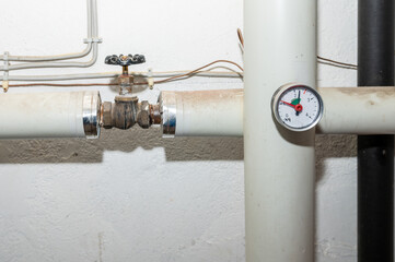 Heizungsanlage für Fernwärme in einem Altbau. Rohre mit Apsterrventil und Gradmesser