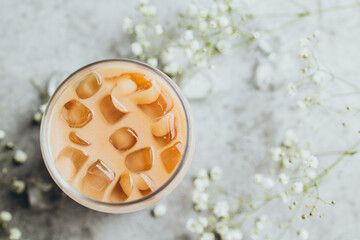 Glass of cold iced coffee on gray background
