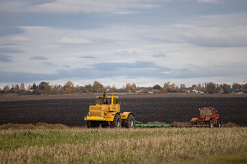 Fototapeta premium old model tractor working in the field.
