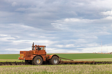 old model tractor working in the field