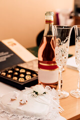 Fototapeta na wymiar Wedding rings, champagne, sweets on the table. Wedding Day