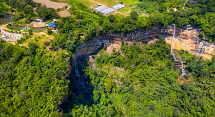 Fototapeta na wymiar Aerial view photo from flying drone of Two steep waterfalls on the rock cliff at canyon Nam Nao in Phetchabun Province unseen Thailand.Conserve Mineral resources of world Concept.