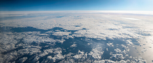 view from the airplane window landscape above the clouds
