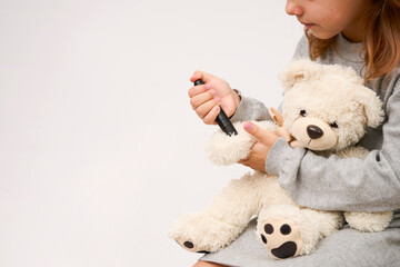 Little girl checking diabetes test to toy bear