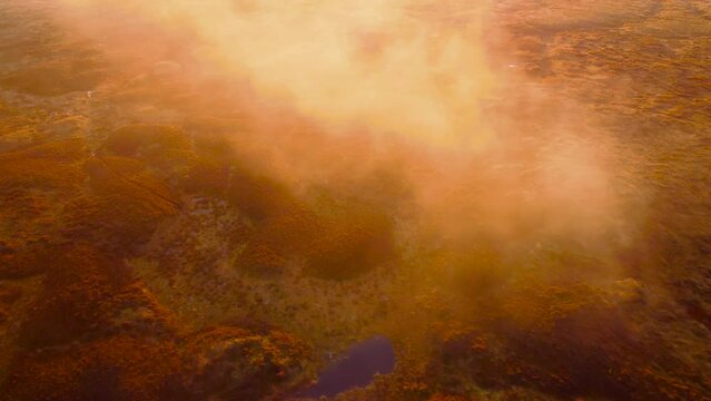 majestic drone flight over moor and heather landscape during orange colored sunset at Peak District,England