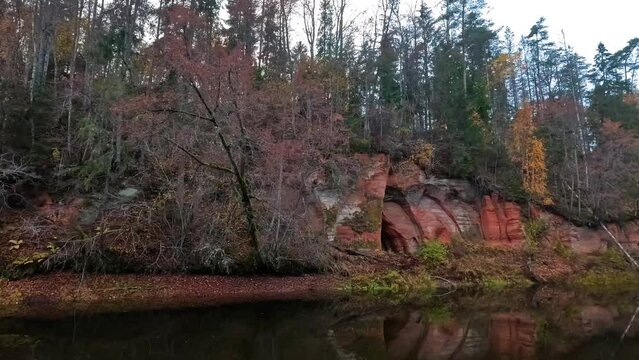 Angels Cave, a Red Sandstone Cliff  in a Shape of Angel Wings, at the River Salaca in Skanaiskalns Nature Park in Mazsalaca, Latvia, Autumn Time. Sandstone Geological Formation
