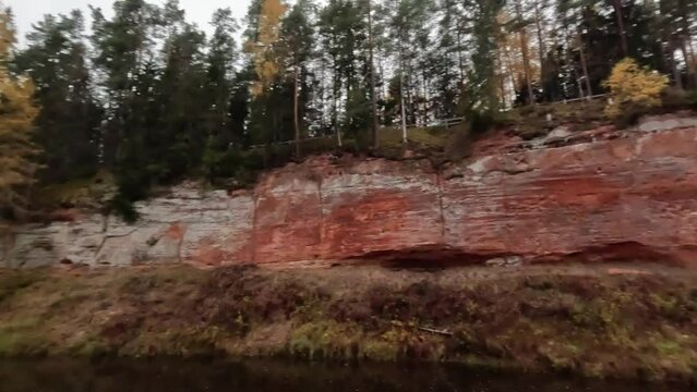The Echo Cliff, Red Sandstone  Skanaiskalns Cliffs at the River Salaca in Skanaiskalns Nature Park  Mazsalaca, Latvia, Autumn Time. Sandstone Geological Formation