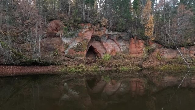 Angels Cave, a Red Sandstone Cliff  in a Shape of Angel Wings, at the River Salaca in Skanaiskalns Nature Park in Mazsalaca, Latvia, Autumn Time. Sandstone Geological Formation