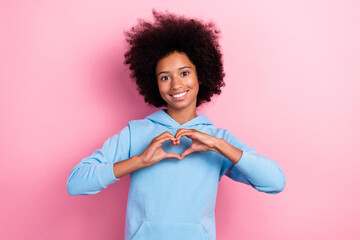 Photo portrait of cute little girl fingers arms showing heart shape toothy smile wear trendy blue outfit isolated on pink color background