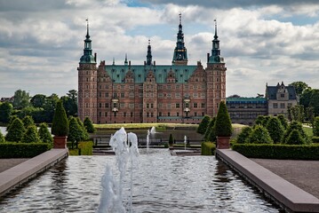 Historic Frederiksborg castle with the courtyard and fountains in Hilerod, Denmark