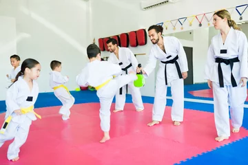 Fotobehang Karate trainers practicing taekwondo with children © AntonioDiaz