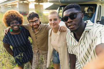 Point of view - SELFIE. Self-photograph POV. Handsome black man in his 20s wearing short-sleeved white stripped shirt and sunglasses taking a photo with his multiracial friends. Van life. High quality
