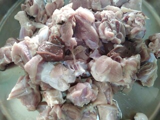 Cutting pieces of mutton on a bowl