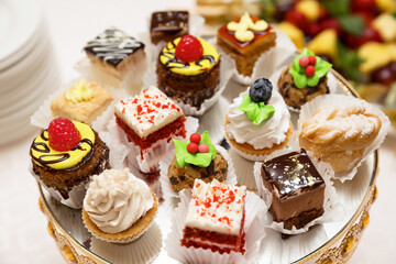 small assorted cakes decorated with berries and confectionery