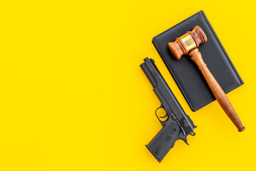 Gun law concept. Hand gun weapon and judges gavel. Crime background