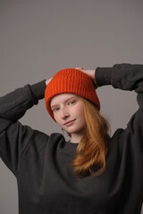 young girl model in orange cap isolated on gray background. Product photo mockup for fashion brands and marketplaces.