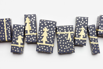 Christmas banner with close up wrapped paper gift boxes on white fon, packaging presents for holidays. Handmade New Year gifts decorated cutting golden paper fir. Xmas, New Year background