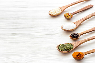 Powdered spices and herbs in wooden spoons. Colorful cooking background