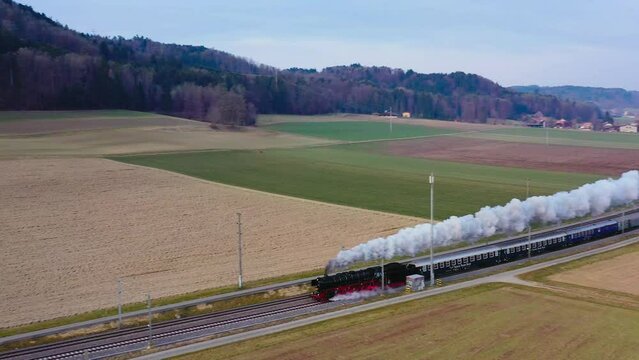 Pacific BR01 01 202 steam locomotive train traveling cross country in Switzerland. It's home-base is in Lyss. A happy site for trainspotters.