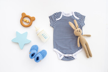 Newborn baby bodysuit with rabbit toy, flat lay, top view