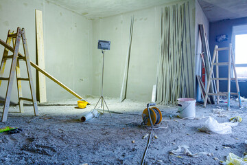 Spotlight illuminates the room walls of the building under construction, work in progress