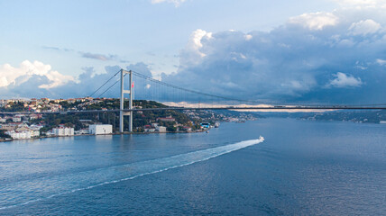 Istanbul next to the 15 Temmuz bridge, aerial view of the Bosporous shore with ferry crossing beneath