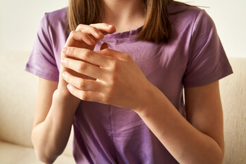 Teenage girl practicing EFT or emotional freedom technique - tapping on the side of the hand point