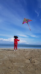 child playing with kite on beach