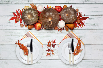 Served two plates at the table decorated with pumpkins and autumn leafs