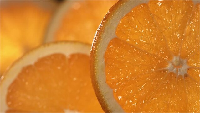 Drop of Orange Water flows down the surface of a ripe juicy Orange slice. Slow Motion 4K