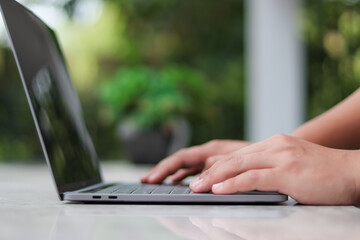 Asian man typing on black monitor laptop keyboard or notebook computer to check email. Prepare to present at the meeting Get information for online shopping or Internet banking operations.