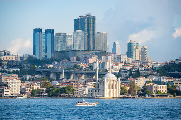 Naklejka premium Skyscrapers of istanbul behind Ortaköy Camii mosque and city behind, aerial view of the Bosporous in Istanbul